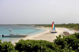 sandstrand mit boot yacht und segelboot vom luxuriösen modernen designer hotel und resort auf den turks- und caicosinseln in der karibik daneben sonnenliegen